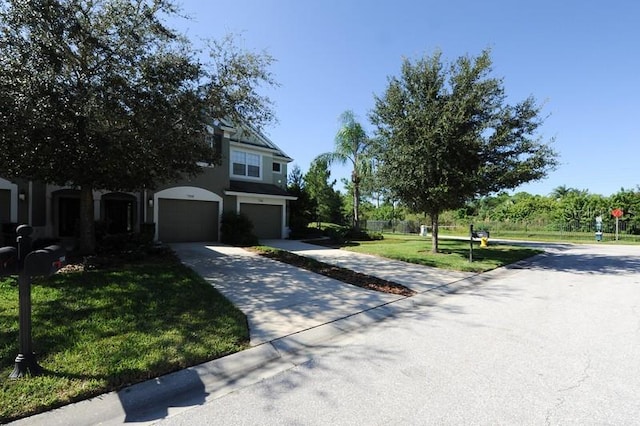 view of front facade with a front lawn and concrete driveway