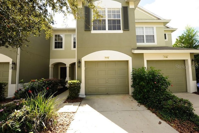 view of front of home with driveway, an attached garage, and stucco siding