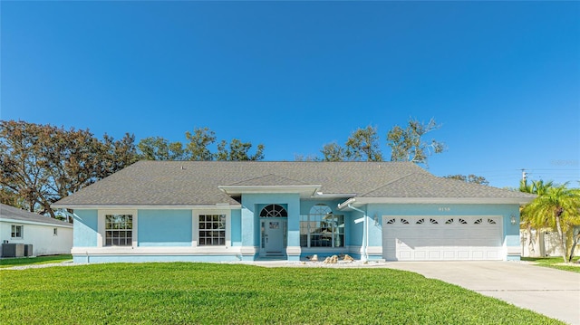 single story home featuring a garage, driveway, a front yard, and stucco siding