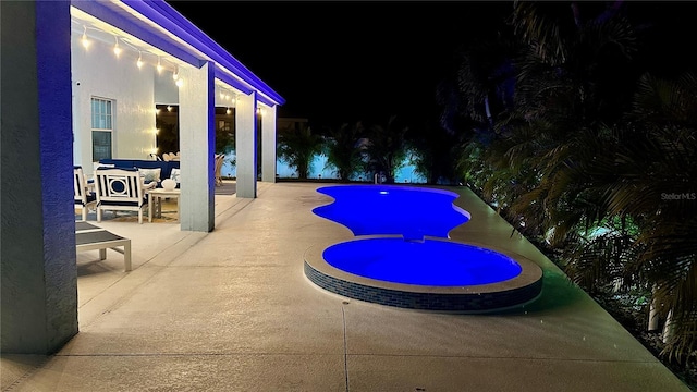 pool at twilight featuring a patio area