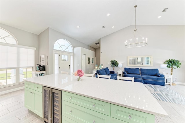 kitchen with open floor plan, wine cooler, a chandelier, and green cabinetry