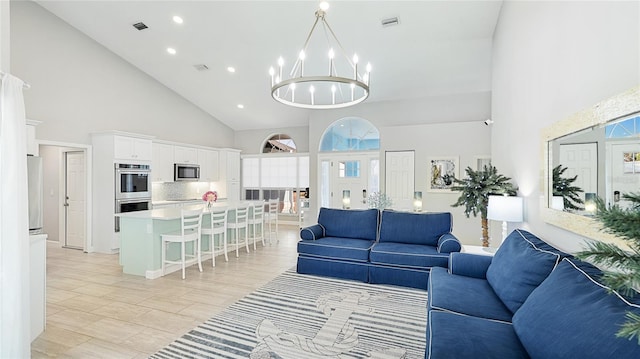 living area featuring a high ceiling, visible vents, a notable chandelier, and recessed lighting