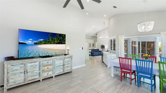 living room with high vaulted ceiling, visible vents, baseboards, and ceiling fan with notable chandelier