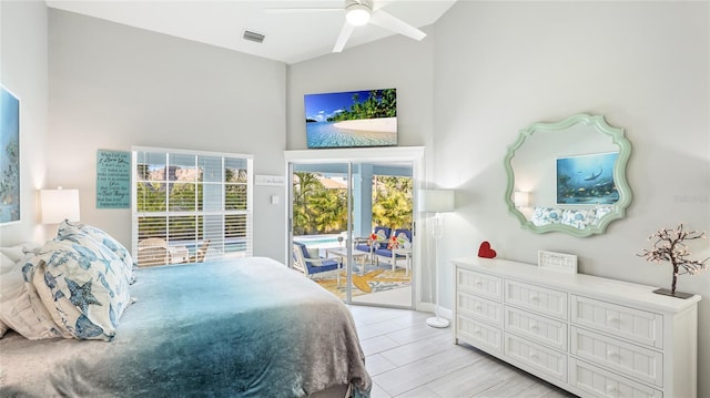 bedroom featuring visible vents, a towering ceiling, ceiling fan, access to outside, and light wood-style floors