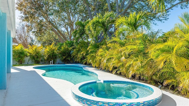 view of swimming pool with a patio area, a fenced backyard, and a pool with connected hot tub