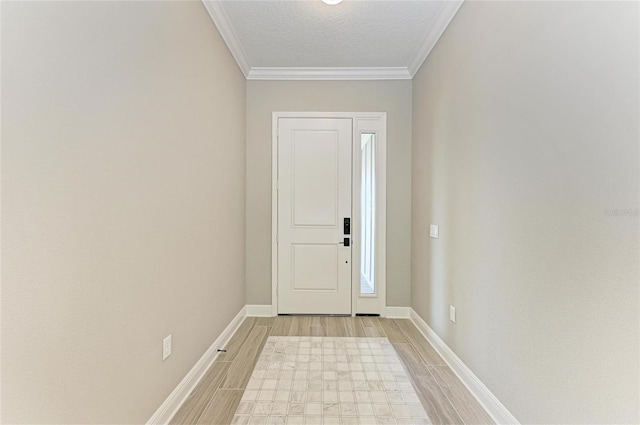 foyer entrance with wood finish floors, crown molding, a textured ceiling, and baseboards