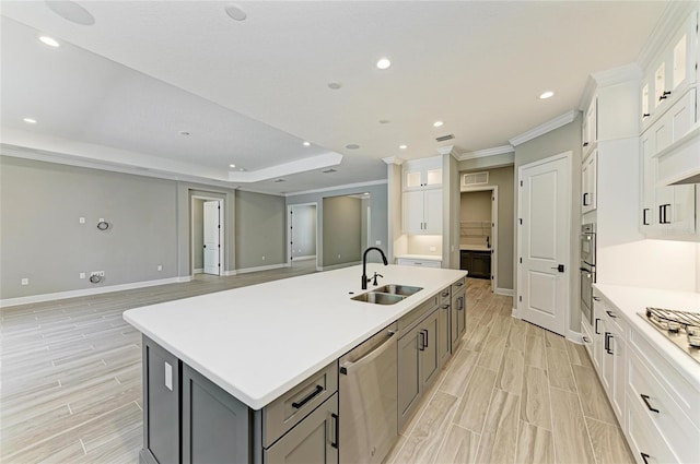 kitchen featuring a sink, light countertops, gray cabinets, dishwasher, and an island with sink