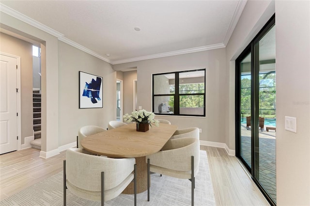 dining room featuring light wood-style floors, baseboards, stairs, and ornamental molding