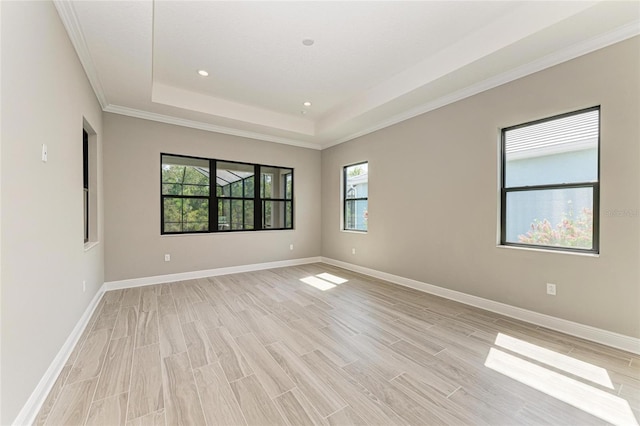 unfurnished room with recessed lighting, baseboards, ornamental molding, light wood-type flooring, and a raised ceiling