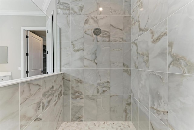 full bathroom featuring tiled shower, vanity, and crown molding