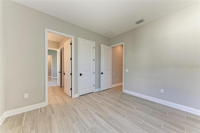 interior space featuring wood tiled floor, visible vents, and baseboards