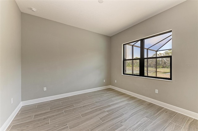 unfurnished room featuring baseboards and wood finish floors