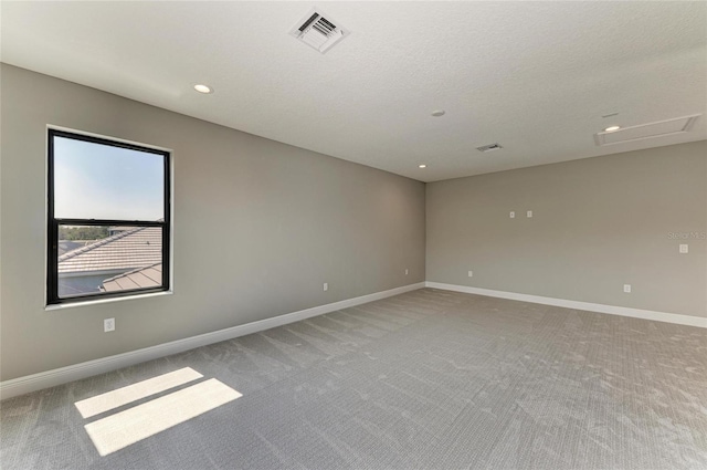 spare room featuring baseboards, light carpet, visible vents, and attic access