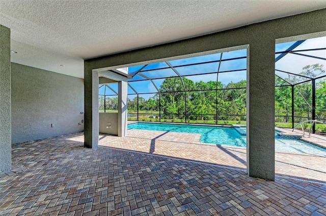 outdoor pool with glass enclosure and a patio area