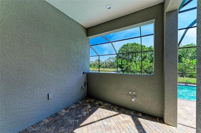 exterior space with glass enclosure and an outdoor pool