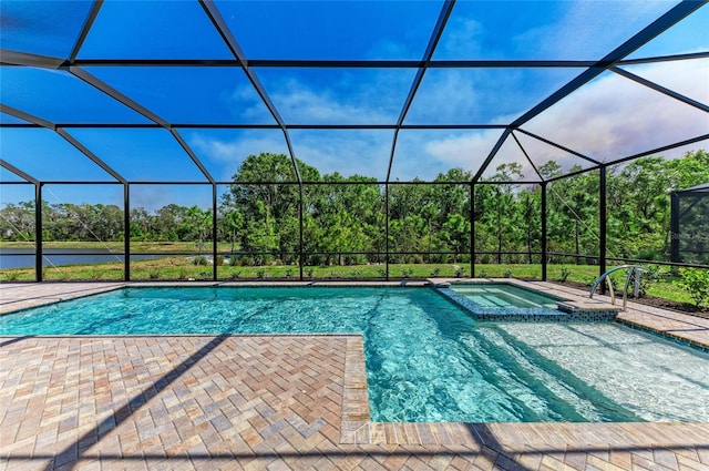 view of pool with a patio, glass enclosure, and a pool with connected hot tub