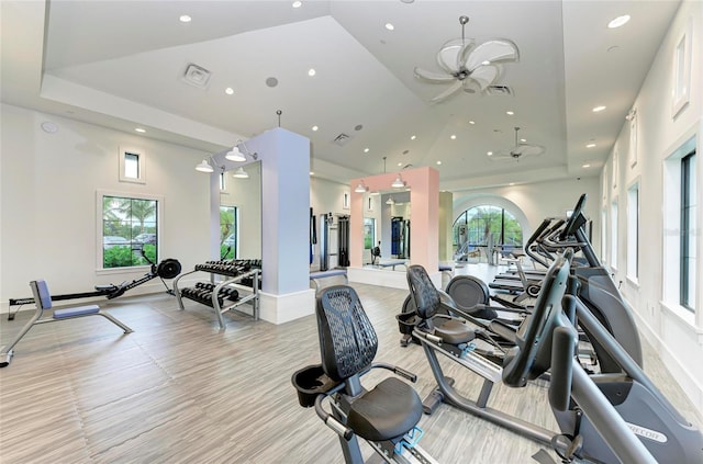 gym featuring a wealth of natural light, a raised ceiling, and visible vents