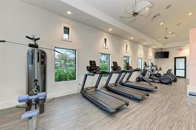 gym with recessed lighting, visible vents, a high ceiling, wood finished floors, and baseboards