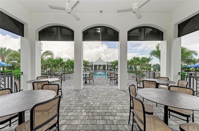 view of patio featuring fence, outdoor dining area, and a ceiling fan