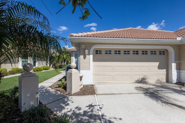 mediterranean / spanish home featuring a tiled roof, concrete driveway, and stucco siding