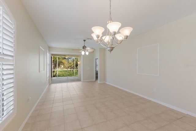 spare room featuring ceiling fan with notable chandelier and baseboards