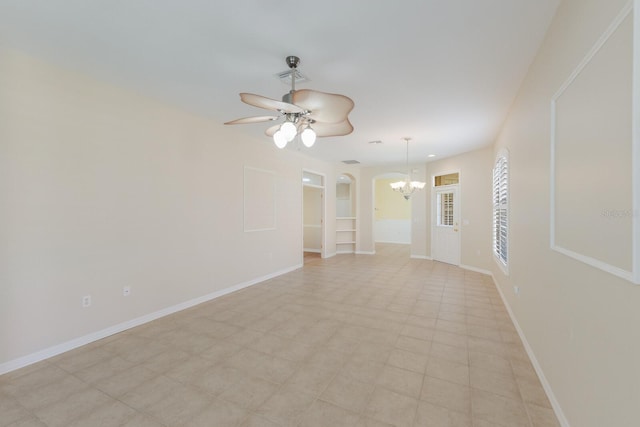 spare room with ceiling fan with notable chandelier, arched walkways, visible vents, and baseboards