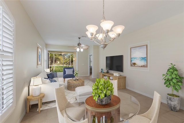 dining area featuring light tile patterned floors, baseboards, and ceiling fan with notable chandelier