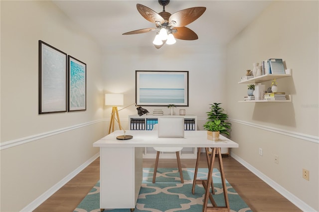 home office featuring ceiling fan, wood finished floors, and baseboards