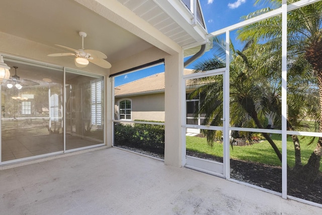 unfurnished sunroom with ceiling fan