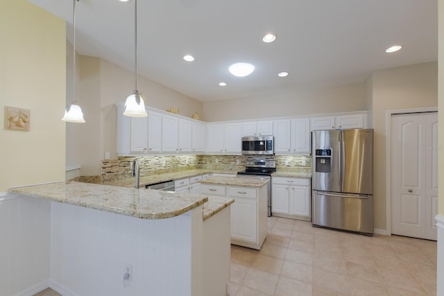 kitchen with tasteful backsplash, white cabinets, light stone counters, a peninsula, and stainless steel appliances