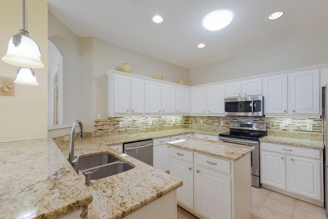 kitchen featuring white cabinets, decorative backsplash, stainless steel appliances, and a sink