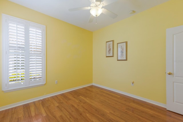 spare room with ceiling fan, baseboards, and wood finished floors