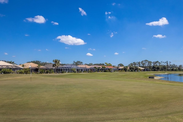 view of property's community with a water view and a lawn