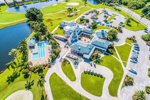 drone / aerial view with view of golf course and a water view