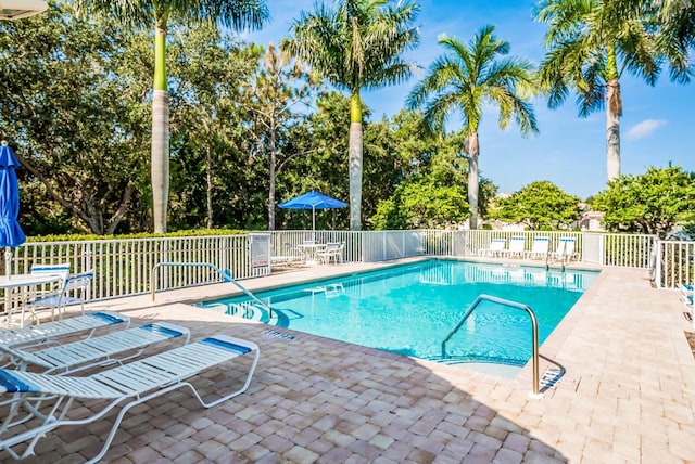 pool featuring fence and a patio