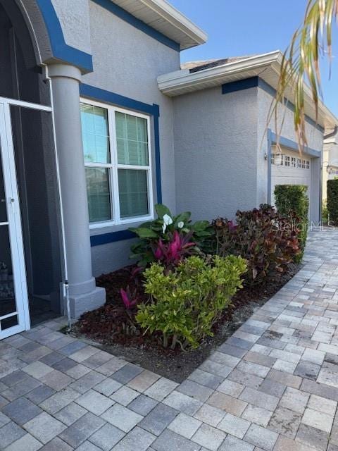 view of property exterior with an attached garage and stucco siding