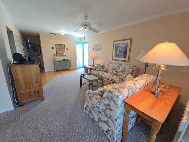 living area featuring ornamental molding, baseboards, and a ceiling fan