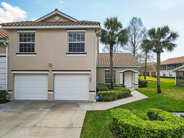 view of front facade with an attached garage, concrete driveway, a tiled roof, stucco siding, and a front lawn