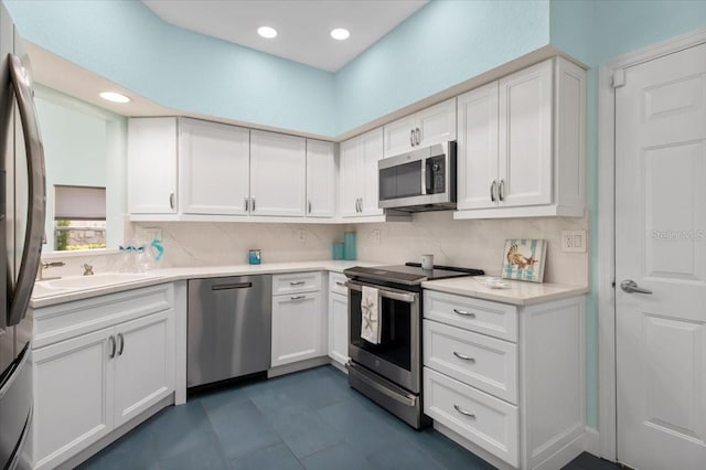 kitchen with white cabinetry, appliances with stainless steel finishes, and backsplash