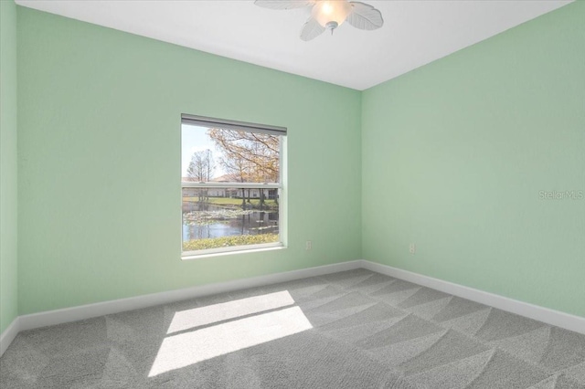 spare room featuring carpet floors, baseboards, and a ceiling fan