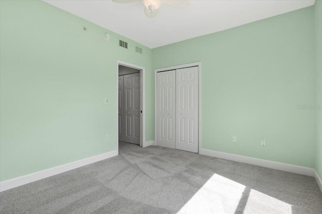 unfurnished bedroom featuring light carpet, a closet, visible vents, and baseboards