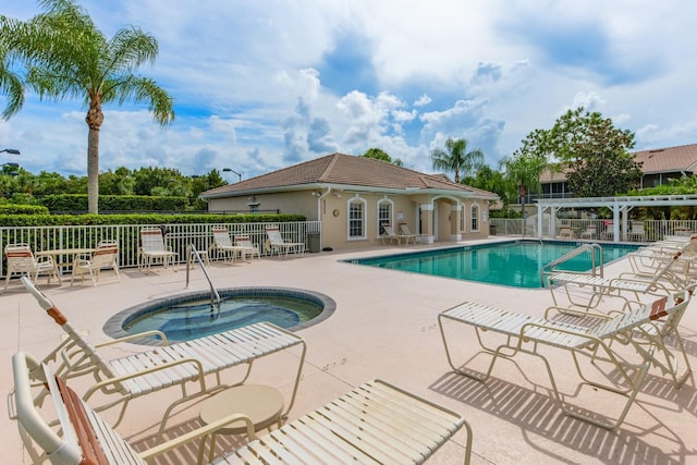 community pool featuring fence, a hot tub, and a patio