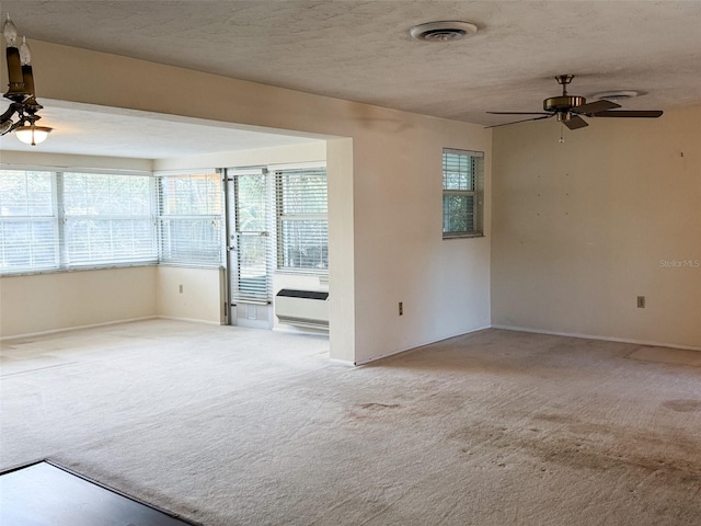 unfurnished room featuring carpet floors, visible vents, and a healthy amount of sunlight