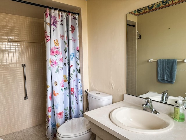 bathroom featuring toilet, a tile shower, and vanity