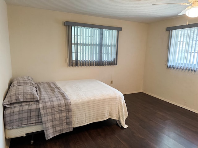 bedroom featuring ceiling fan, baseboards, and wood finished floors