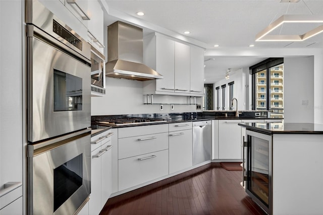 401 S Palm Ave Unit 801, Sarasota, FL 34236 - kitchen with stainless steel appliances, wall chimney range hood, beverage cooler, dark countertops, and white cabinetry