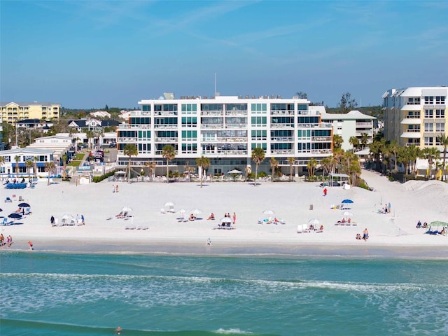 birds eye view of property with a water view and a beach view