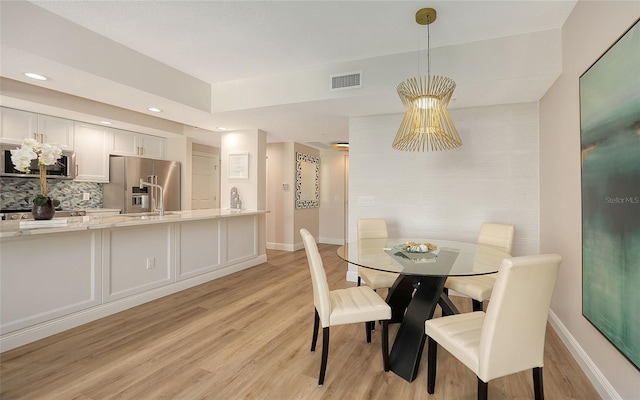 dining area with light wood-style floors, baseboards, visible vents, and recessed lighting