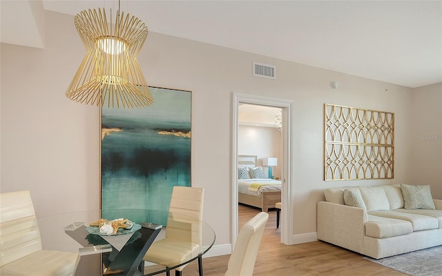 dining room with light wood-style floors, baseboards, and visible vents