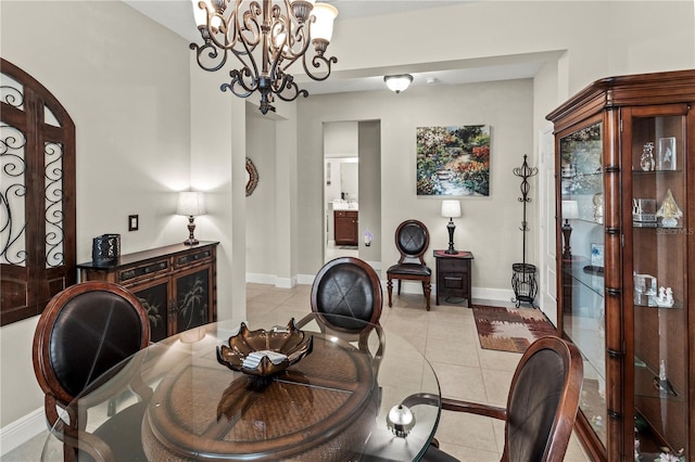 dining area featuring a notable chandelier, light tile patterned flooring, and baseboards